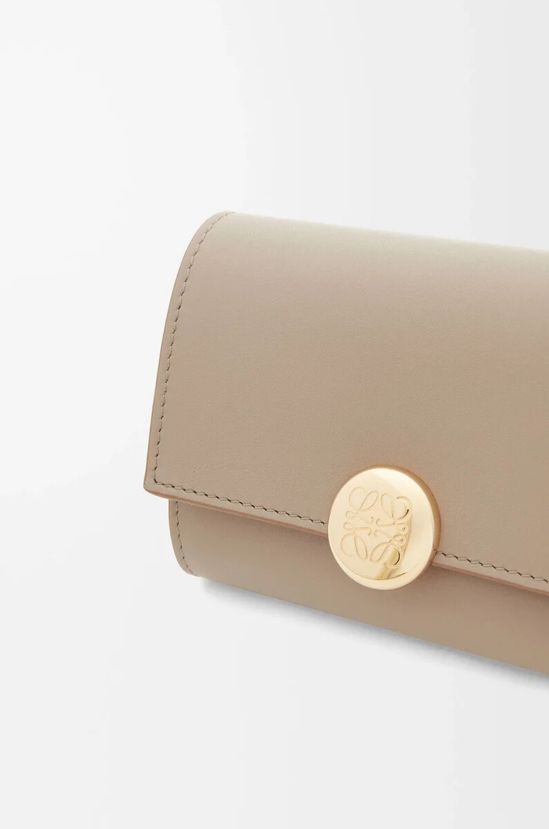 cartera vertical pequeña pebble en piel de becerro napa brillante arena
