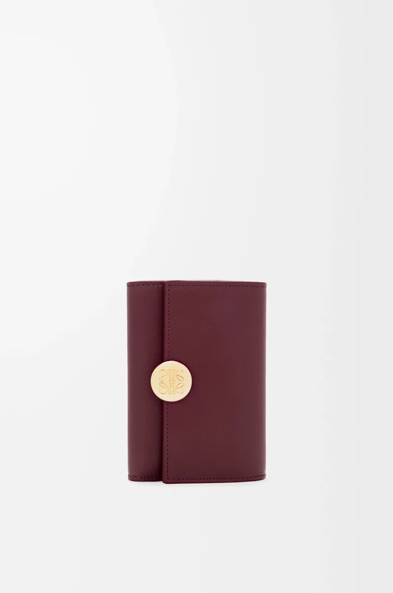 cartera vertical pequeña pebble en piel de becerro napa brillante color burdeos