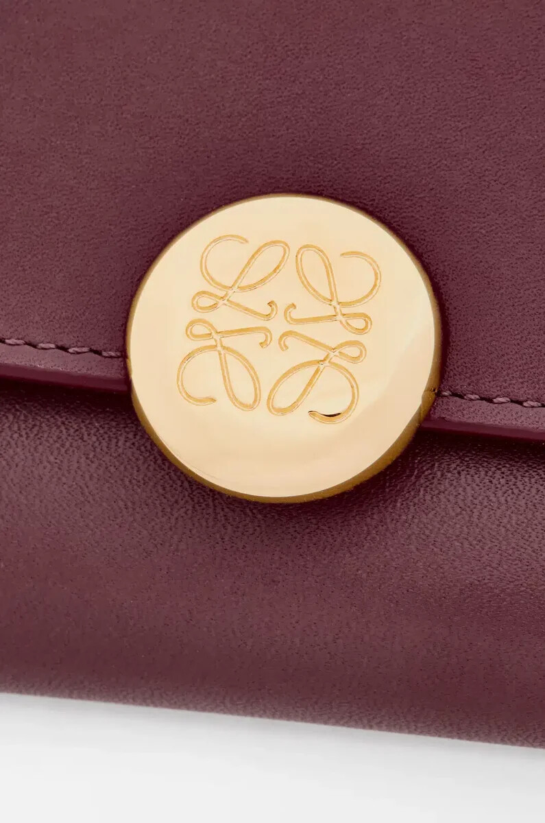 cartera vertical pequeña pebble en piel de becerro napa brillante color burdeos