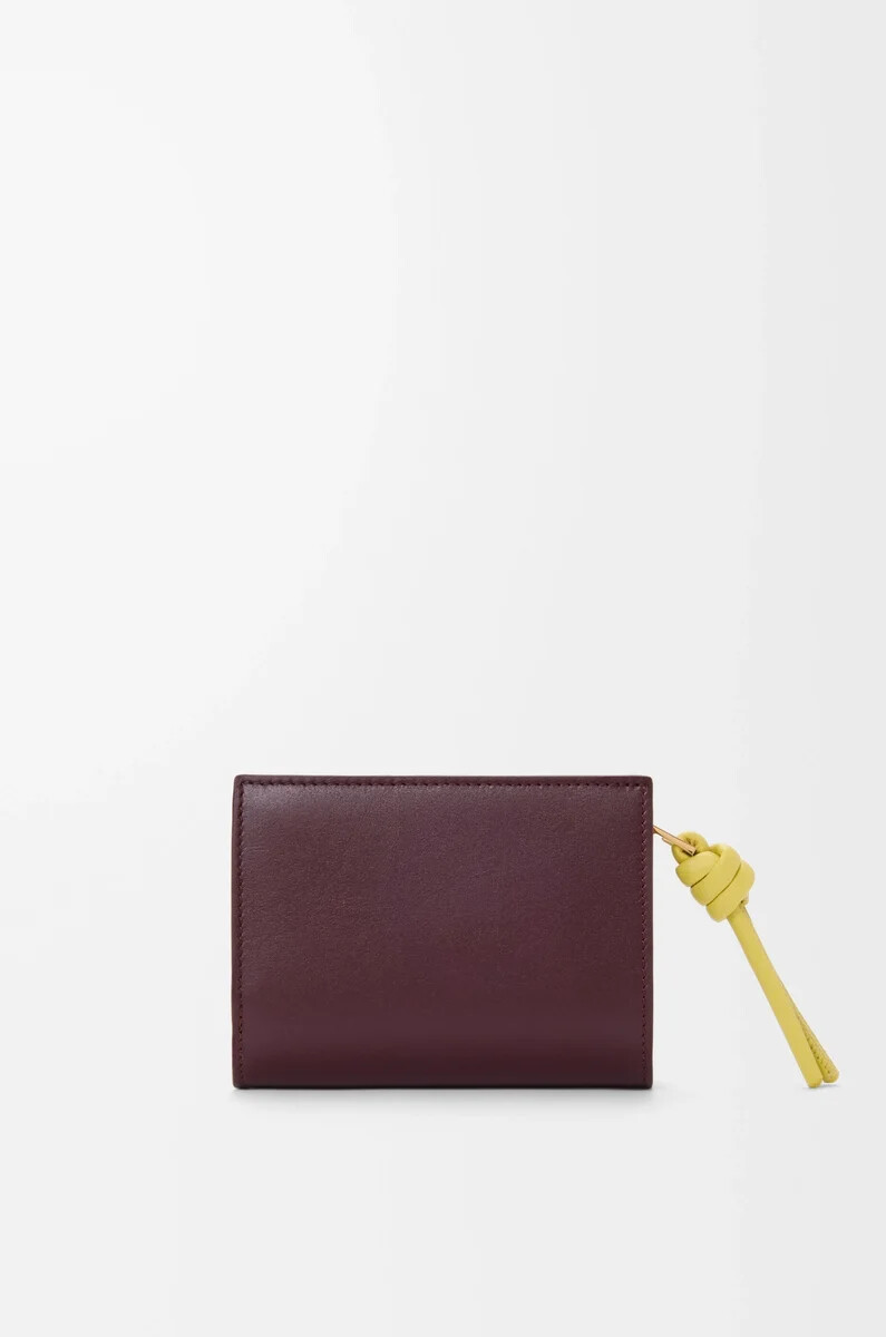 cartera compacta knot en piel de becerro napa brillante color burdeos oscurocitrino claro