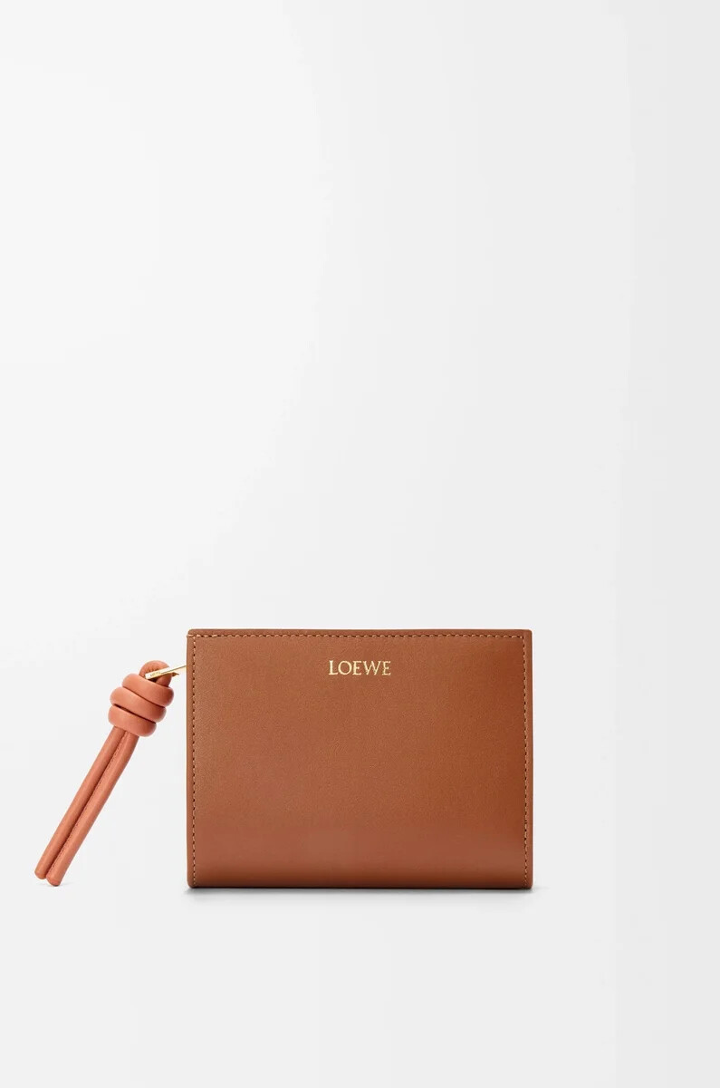 cartera compacta knot en piel de becerro napa brillante color tostadopapaya