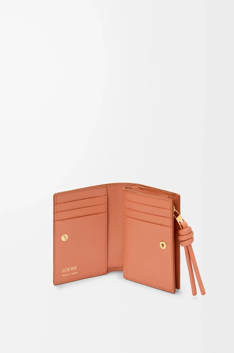 cartera compacta knot en piel de becerro napa brillante color tostadopapaya