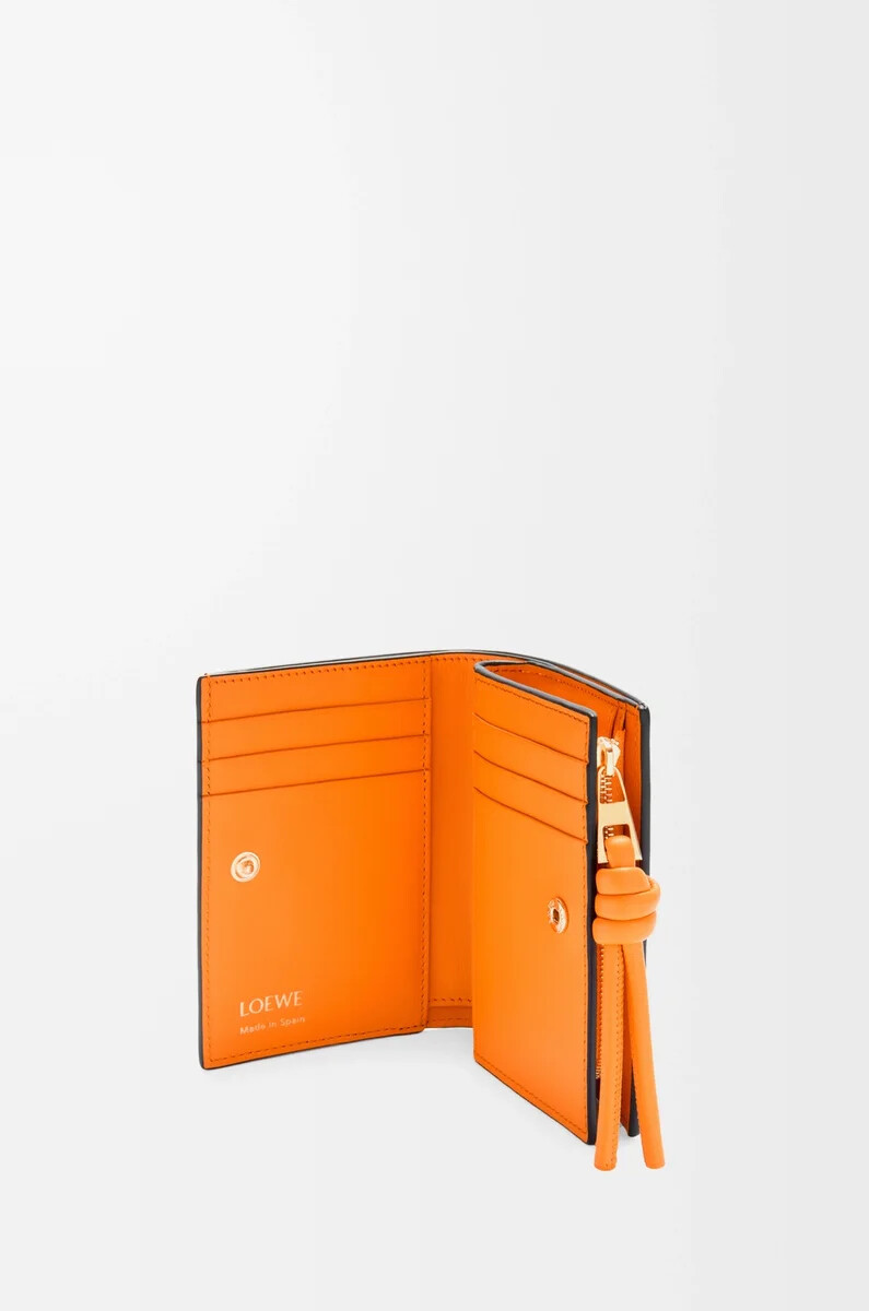 cartera compacta knot en piel de becerro napa brillante negronaranja brillante